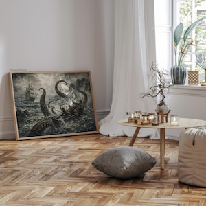 May include: A framed print depicts a dramatic sea battle with a ship and a giant octopus. The artwork is in shades of gray and black, with a wooden frame. The print is leaning against a white wall on a wooden floor.