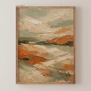 May include: A framed abstract landscape painting in shades of orange, green, and beige. The artwork uses textured brushstrokes to create depth and movement. The wooden frame provides a rustic aesthetic. The painting is a piece of wall art.