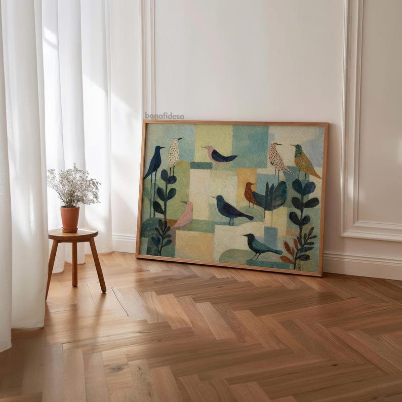 May include: A framed artwork featuring a colorful bird illustration. The artwork showcases various birds in shades of blue, pink, and yellow against a geometric background. The piece is displayed in a room with a wooden floor and a small side table.