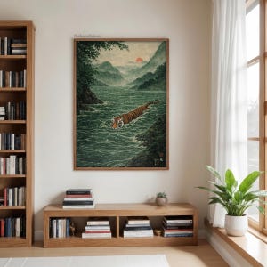 May include: Framed art print showing a tiger swimming in a river. The artwork depicts a tiger with orange and black stripes in a green river, with mountains and a sunset in the background. The print is in a wooden frame.