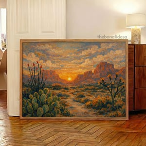 Può includere: Dipinto paesaggistico incorniciato che raffigura una scena desertica al tramonto. L'opera presenta un sentiero che conduce al sole, con cactus e piante del deserto in primo piano. Il cielo è pieno di nuvole e il dipinto è in una cornice di legno.