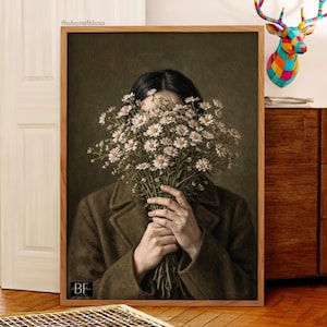 May include: A framed art print featuring a person holding a large bouquet of white daisies. The person is wearing a dark green coat. The background is a muted green color. The artwork has a vintage aesthetic.