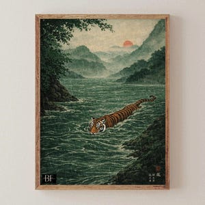 May include: A framed art print depicting a tiger swimming in a river, in the style of Japanese art. The tiger has orange and black stripes. The background shows mountains, a red sun, and a green river.