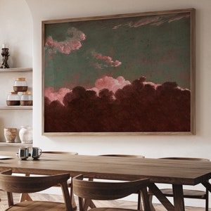 May include: A framed abstract painting with a dark green background and pink clouds. The clouds are painted in a soft, watercolor style and create a sense of depth and movement. The painting is framed in a simple, wooden frame.