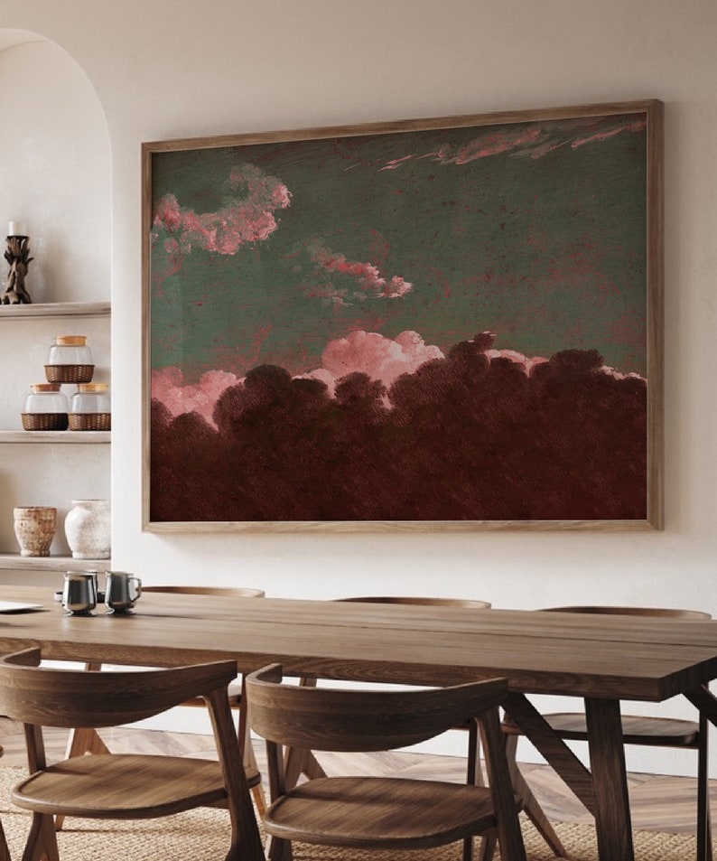 May include: A framed abstract painting with a dark green background and pink clouds. The clouds are painted in a soft, watercolor style and create a sense of depth and movement. The painting is framed in a simple, wooden frame.