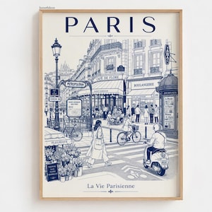 Könnte beinhalten: Ein gerahmter Kunstdruck mit einer detaillierten blau-cremefarbenen Strichzeichnung einer Pariser Straßenszene. Der Text PARIS steht oben und La Vie Parisienne unten. Die Illustration zeigt ein Café, einen U-Bahn-Eingang und Menschen.