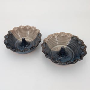 May include: Two blue and white ceramic apple pie dishes with a fluted edge and a center cone.