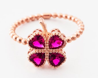Op de afbeelding: Een ring van roségoud met een klavertjevier ontwerp met roze edelstenen.