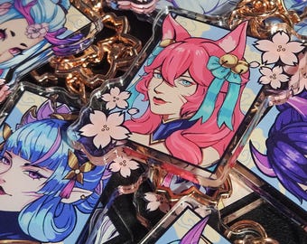 May include: A set of five colorful anime-style character keychains with a pink, blue, and purple color scheme. The keychains feature a variety of characters with different hairstyles and accessories. The keychains are made of clear acrylic and have a glossy finish.