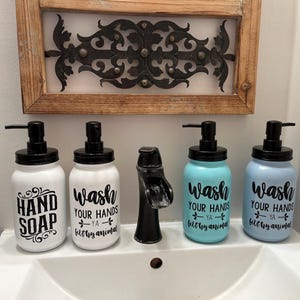 May include: Four white ceramic soap dispensers with black lids and black lettering. The dispensers are labeled "Hand Soap", "Wash Your Hands Ya Filthy Animal", and "Wash Your Hands Ya Filthy Animal".