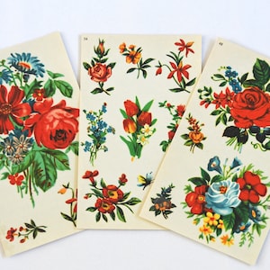 May include: Three vintage floral print sheets with illustrations of roses, tulips, and other flowers in red, blue, yellow, and orange. Each sheet has a different arrangement of botanical illustrations, with a cream background.
