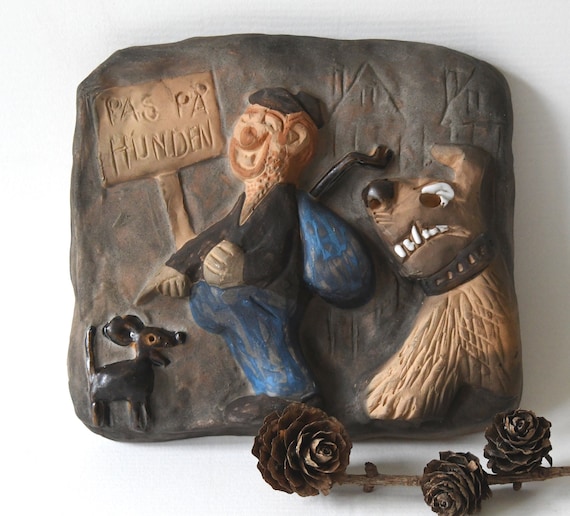A hand-painted ceramic tile door sign with MCM / Scandinavian-modern aesthetic and a cheeky 'Beware of the Dog' message — feels like something you'd find in a Danish design museum gift shop.