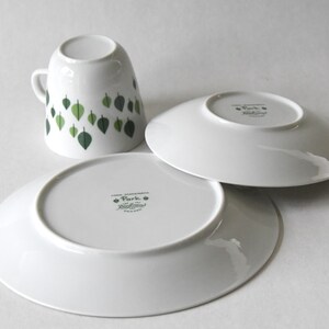 Puede incluir: Juego de taza y platillos de cer&aacute;mica blanca con dise&ntilde;o de hojas. La taza presenta hojas verdes, y los platillos son blancos. El juego es de la colecci&oacute;n "Park".