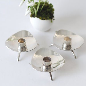 Tres candelabros. Carl Cohr, Dinamarca. Platería, 1959. ATLA. Candelabros plateados. Diseño modernista danés.
