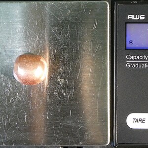 K&ouml;nnte beinhalten: Eine digitale Waage mit einem braunen Stein auf der Wiegeplattform. Die Waage zeigt 12,7 Gramm an. Die Waage hat eine Kapazit&auml;t von 600 Gramm und eine Ablesegenauigkeit von 0,1 Gramm.