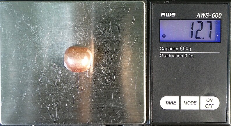 K&ouml;nnte beinhalten: Eine digitale Waage mit einem braunen Stein auf der Wiegeplattform. Die Waage zeigt 12,7 Gramm an. Die Waage hat eine Kapazit&auml;t von 600 Gramm und eine Ablesegenauigkeit von 0,1 Gramm.