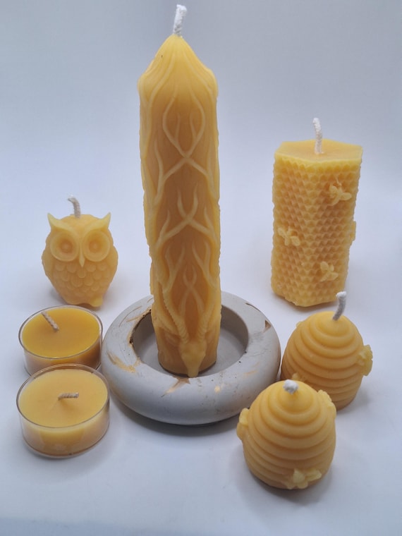 beeswax gift set. consists of 2 beehives, 1 owl, 2 tealights, 1 honeycomb with bees on it and 1 pillar candle that is a deer with antlers