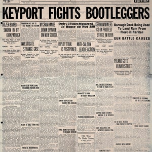 Puede incluir: Una p&aacute;gina de peri&oacute;dico en blanco y negro con el titular "Keyport Fights Bootleggers". El art&iacute;culo trata sobre una variedad de noticias locales, incluyendo una huelga de mineros alemanes, el aplazamiento de un juicio y una batalla a tiros.