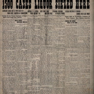 Puede incluir: Un recorte de peri&oacute;dico en blanco y negro del Beverly Banner, fechado el 27 de octubre de 1923, con el titular "1500 Cajas de Licor Incautadas Aqu&iacute;". El art&iacute;culo informa sobre la incautaci&oacute;n de 1500 cajas de licor y 54 hombres por cuatro polic&iacute;as estatales en Charleston. El art&iacute;culo tambi&eacute;n menciona a un equipo de f&uacute;tbol local, el Beverly F.C., que gan&oacute; un partido 7-0.
