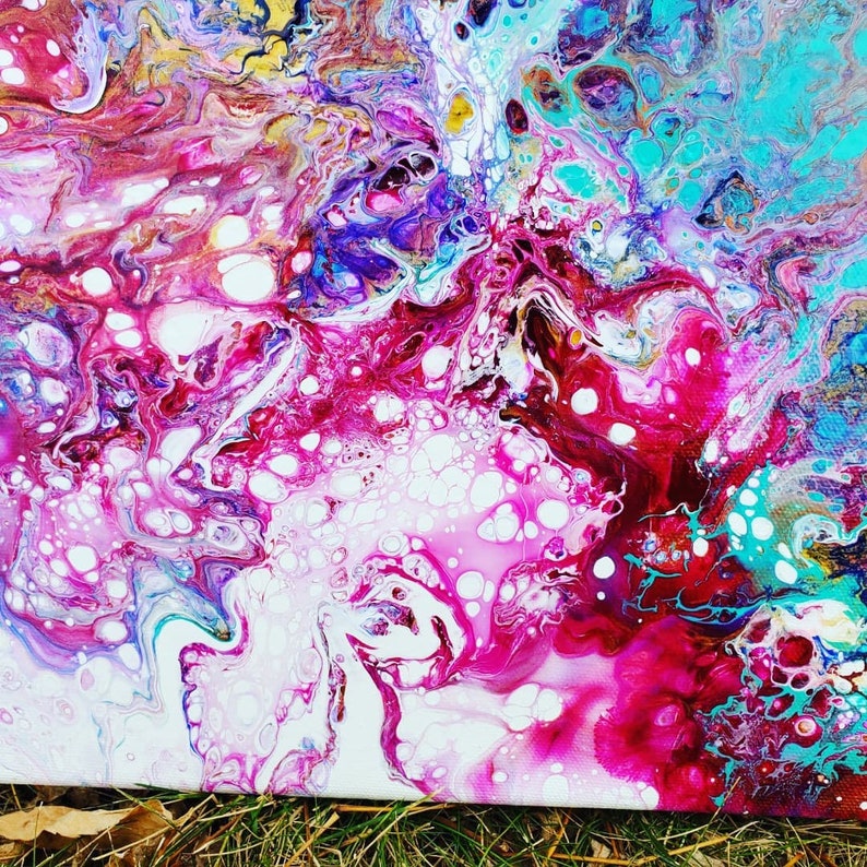 May include: Abstract painting with swirling patterns of pink, white, blue, and gold. The paint has a fluid, almost liquid appearance, creating a sense of movement and energy.