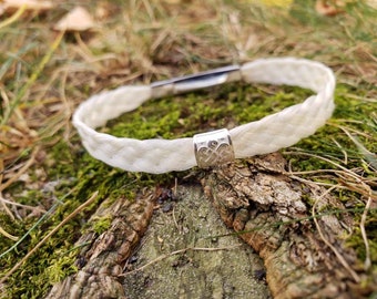 Platt fläta i vitt hästhår (liten) med keltisk knut i sterlingsilver. Bajonettlås i rostfritt stål.