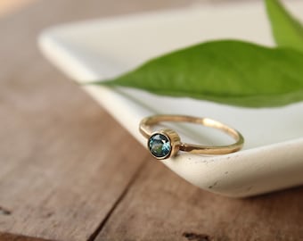 Anillo solitario de oro macizo de 14k con zafiro de Montana y engaste de bisel.