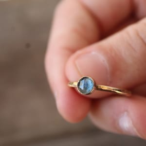 May include: A gold ring with a blue gemstone set in the centre.