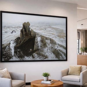 May include: Large framed landscape photograph of a rocky mountain range covered in snow. The photograph is displayed on a white wall in a modern interior setting. The word "UTAH" is visible on a brick wall.