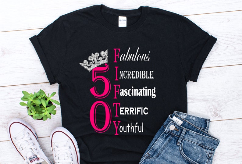 May include: Black t-shirt with a pink number 50 and the words "Fabulous, Incredible, Fascinating, Terrific, Youthful" written vertically. A silver crown is above the number 50.