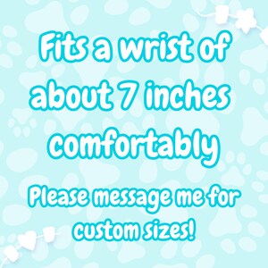 May include: A light blue background with white paw prints and marshmallow-shaped decorations. Text in turquoise reads: "Fits a wrist of about 7 inches comfortably. Please message me for custom sizes!"