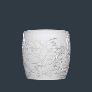 May include: A white cylindrical vase with a detailed relief of peony flowers. The floral design wraps around the entire vase, creating a textured surface. The vase has a smooth, unadorned rim and a dark background.