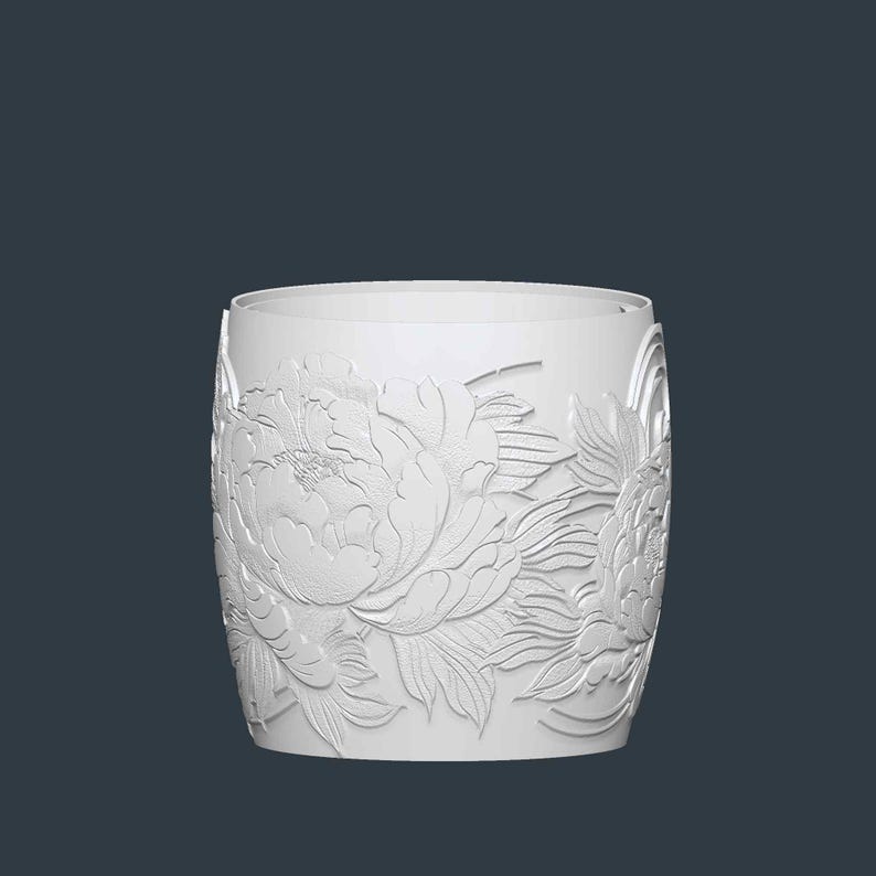 May include: A white cylindrical vase with a detailed relief of peony flowers. The floral design wraps around the entire vase, creating a textured surface. The vase has a smooth, unadorned rim and a dark background.
