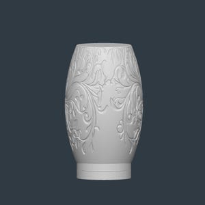 May include: A white, oval-shaped decorative vase with an intricate floral pattern carved into its surface. The vase has a wide base and a slightly narrower top, with a smooth, unadorned rim. The background is a solid, dark gray.