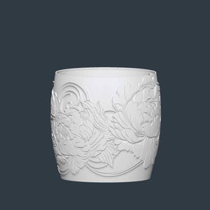 May include: A white, cylindrical container with a floral relief pattern. The design features large peony blossoms and leaves, creating a textured surface. The container has a smooth, rounded top and a dark background.