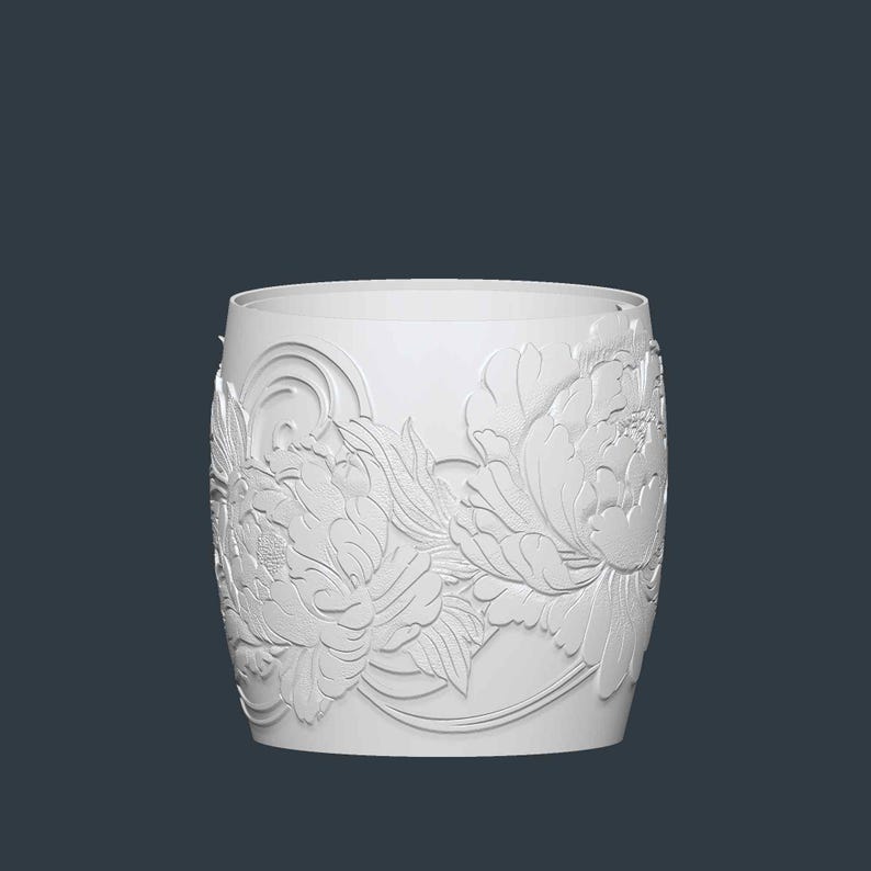 May include: A white, cylindrical container with a floral relief pattern. The design features large peony blossoms and leaves, creating a textured surface. The container has a smooth, rounded top and a dark background.