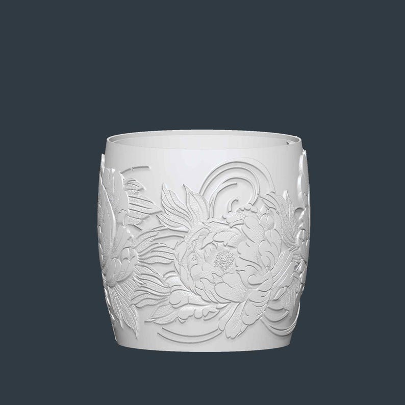 May include: A white cylindrical container with a floral relief design. The detailed carving features large peony blooms and stylized leaves. The container has a smooth, unadorned rim and a solid base, set against a dark background.