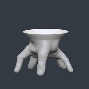 May include: A white, hand-shaped decorative bowl with a wide, circular opening. The bowl is supported by a detailed, textured hand with fingers spread out. The design is a unique and artistic home decor item.