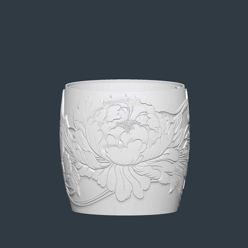 May include: A white cylindrical container with a detailed relief of a peony flower. The floral design wraps around the container, showcasing petals and leaves. The background is a solid, dark blue-gray.