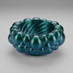 May include: A deep teal bowl with a metallic, iridescent finish. The exterior is covered in a dense cluster of spherical, bubble-like protrusions of varying sizes. The interior of the bowl features a distinct, swirling, spiral-patterned texture.