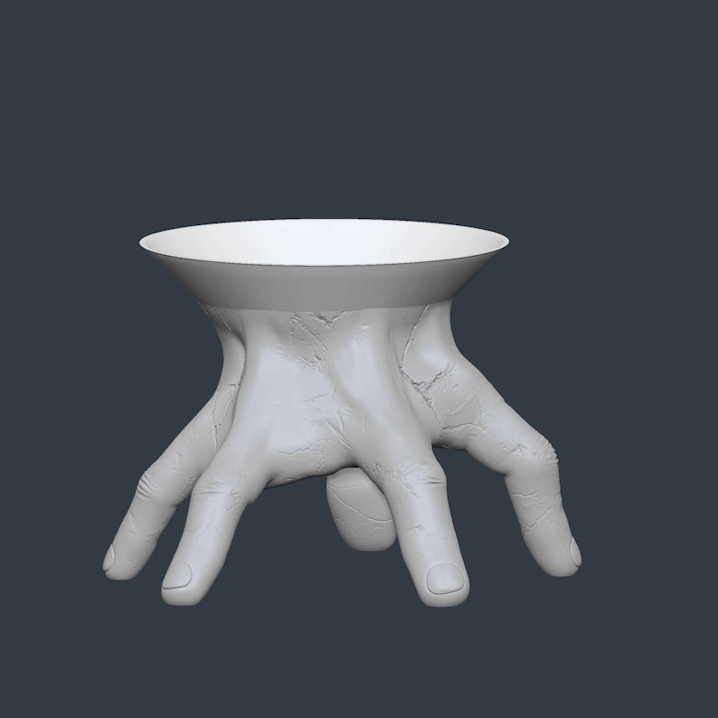 May include: A white, sculptural table with a unique design. The table's base is formed by a hand with fingers spread out, supporting a circular tabletop. The overall aesthetic is modern and artistic, suitable for decorative purposes.