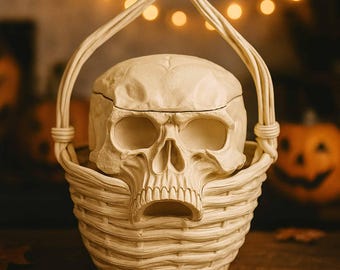 May include: A cream-colored skull-shaped container with a matching woven basket base and handle. The skull has detailed facial features and sits inside the basket. The basket has a textured, woven design, perfect for Halloween decor.