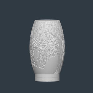May include: A white, oval-shaped vase with intricate floral and leaf patterns carved into its surface. The vase has a wide base and a slightly narrower top, with a smooth, unadorned rim. The design is symmetrical, with the patterns flowing around the vase.