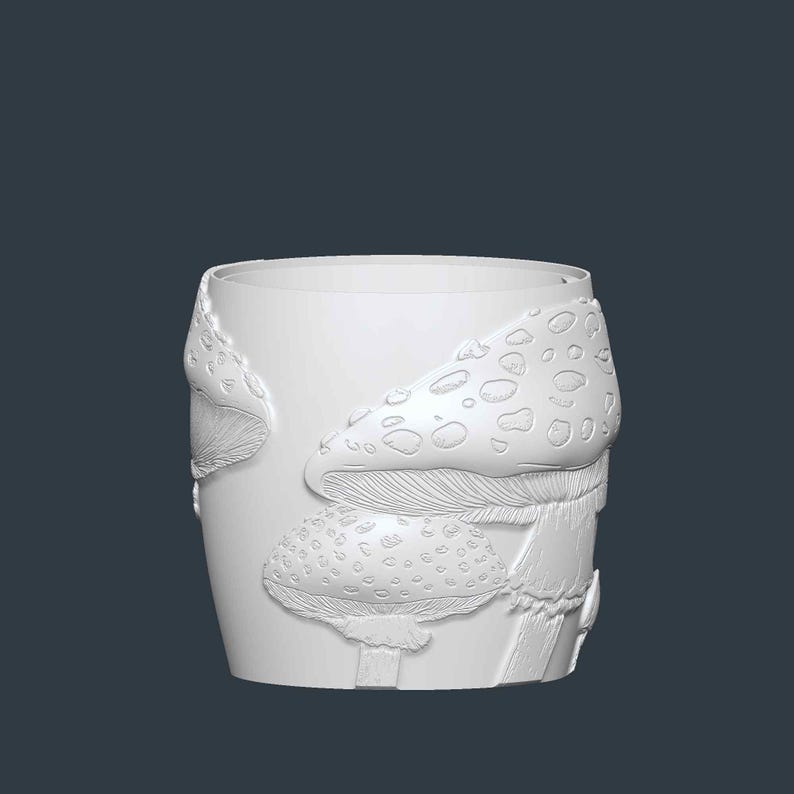 May include: A white ceramic tumbler with a detailed relief of mushrooms. The design features several mushroom caps with textured surfaces and dotted patterns. The tumbler has a cylindrical shape and a smooth, unadorned rim.