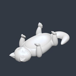 May include: A white, stylized cat figurine lying on its back with its paws and tail raised. The cat has a smiling face and a rounded body, suggesting a playful or whimsical design. The background is a solid, dark gray.