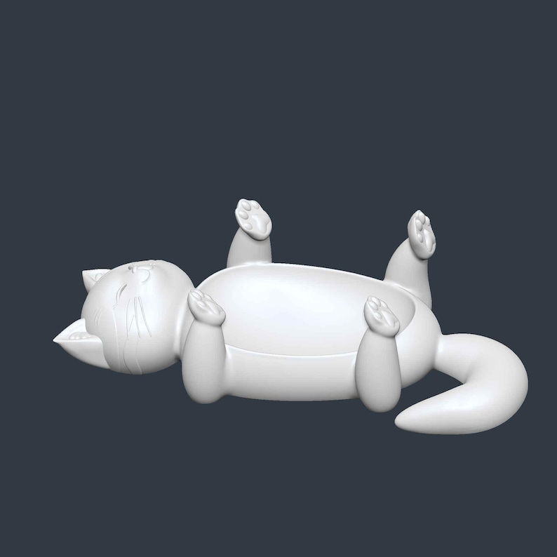 May include: A white, stylized cat figurine lying on its back with its paws in the air. The cat has a rounded body, a curled tail, and a smiling expression. The figurine is a solid color and appears to be made of plastic or ceramic.