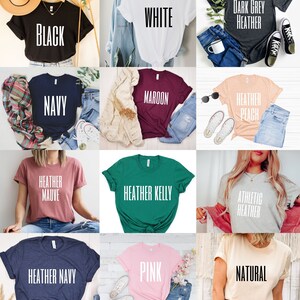 May include: A collage of 12 t-shirts in various colors and styles. The t-shirts feature different text, including "Black", "White", "Dark Grey Heather", "Navy", "Maroon", "Heather Peach", "Heather Mauve", "Heather Kelly", "Athletic Heather", "Heather Navy", "Pink", and "Natural".