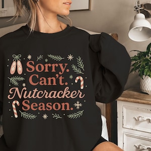 Pu&ograve; includere: Felpa nera con la scritta "Sorry. Can't. Nutcracker Season." in un design festivo. Il design include scarpette da ballo, bastoncini di zucchero e fiocchi di neve. Un capo comodo per le festivit&agrave; natalizie.