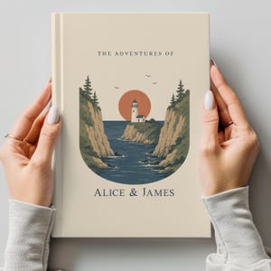 May include: A hardcover book with a beige cover featuring a coastal illustration. The artwork includes a lighthouse, cliffs, ocean, and a setting sun. The text "THE ADVENTURES OF" and "ALICE & JAMES" are printed on the cover.