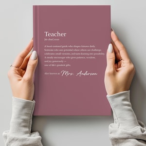 May include: A mauve-colored notebook with the word "Teacher" and its pronunciation at the top. The notebook contains a definition of a teacher and is signed "Mrs. Anderson."