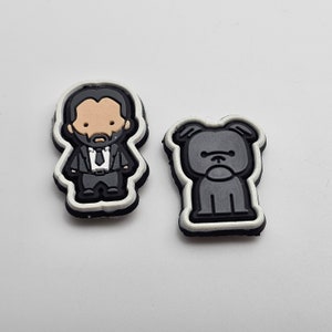 May include: Two black and white rubber patches, one with a cartoon image of a man in a suit and the other with a cartoon image of a dog.